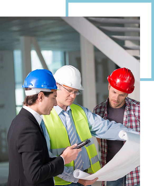 Three men in hard hats looking at a paper.