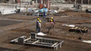 A group of construction workers standing on top of a building.