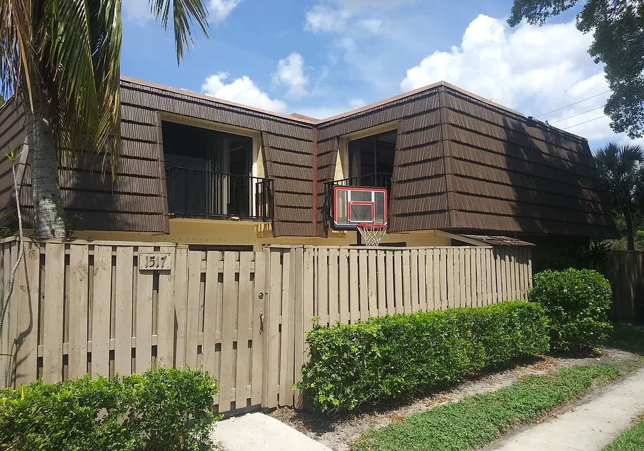 A brown house with a basketball hoop on the side.